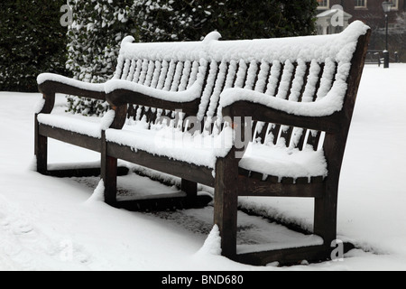 Schneebedeckte Bank im Hyde Park an einem kalten Januartag, London, W2. Stockfoto