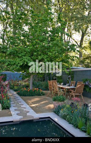 Sommergarten mit Essen um einen Pool im freien Stockfoto