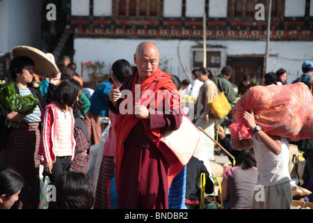 Ein Lama aus der lokalen Dzong blättert durch den Wochenmarkt in Paro, Bhutan. Stockfoto