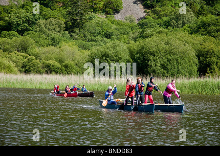 Mädchen genießen paddeln, während Stand-Up in kleinen Booten auf Derwent Water, Borrowdale, The Lake District, Cumbria, UK Stockfoto