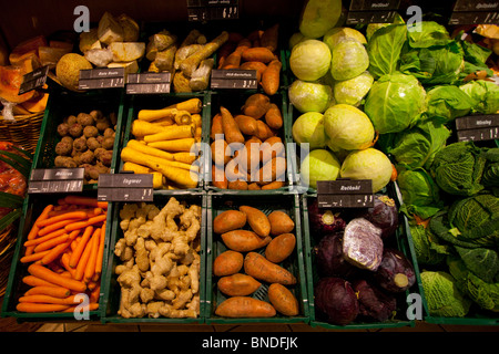 Auf einem Markt werden verschiedene Gemüsesorten präsentiert, darunter Karotten, Rüben, Kartoffeln und verschiedene Kohl. Stockfoto