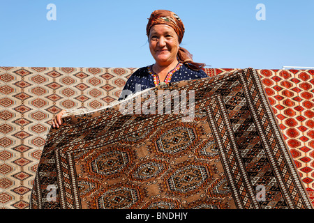 Frau zeigt einen Teppich auf dem Sonntagsmarkt, Ashgabat, Turkmenistan Stockfoto