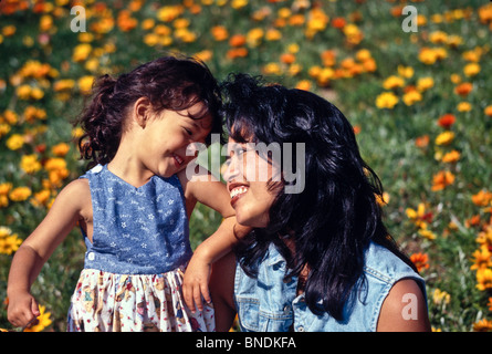 Glückliche Mutter und Tochter 4 Jahre alt Tochter lächelnd Feld Blumen. multi-ethnische Inter rassisch unterschiedlichen Filipina Stockfoto