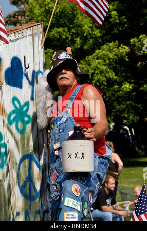 Mann mit Krug Moonshine auf Hillbilly Schwimmer in älteste kontinuierliche Independence Day Parade in Amerika im neuen Pekin, Indiana Stockfoto