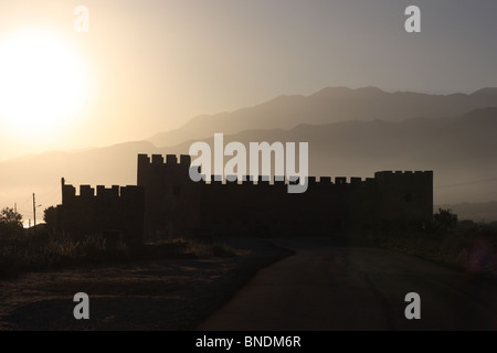 Die Silhouette der Burg Frangokastelo, Südküste von Kreta, Griechenland, in den Sonnenuntergang und vor Bergen Stockfoto