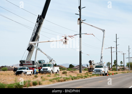 Bauarbeiter in einer Hubarbeitsbühne Körbe Arbeit auf eine neue Stromleitung Übertragung. Stockfoto
