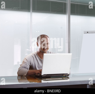 glücklich Kaufmann im Büro, die Arbeiten am Notebook Stockfoto