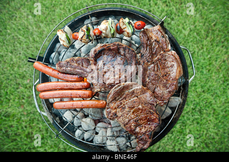 Fleisch, Würstchen und Gemüse auf dem Grill Stockfoto