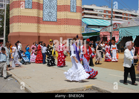 Frauen im Flamenco Kleider am Eingang auf den Boden Feria April Frühjahrsmesse, Sevilla, Provinz Sevilla, Andalusien, Spanien. Stockfoto
