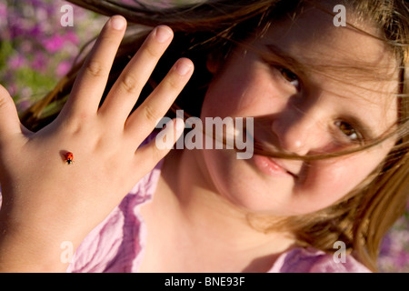 Nahaufnahme eines Mädchens zeigt einen Marienkäfer auf ihrer hand Stockfoto