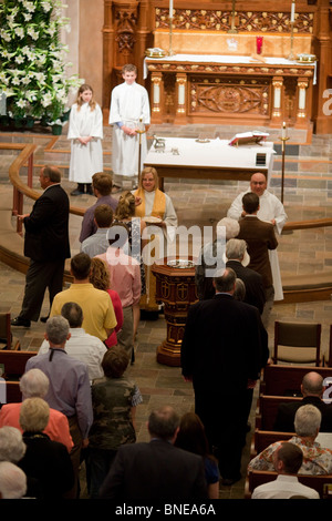 Die Mitglieder der Kirche gehen den Mittelgang entlang, um sich während des Ostersonntagsgottesdienstes in der lutherischen Kirche St. Martin für den Ritus der heiligen Kommunion zu verändern. ©Bob Daemmrich Stockfoto