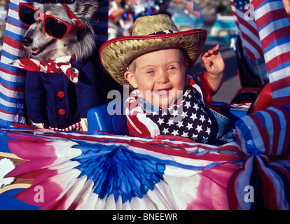 Happy Boy 2-3 Jahre alt mit Down Syndrom Wellen von seinem 'Float' in der Nachbarschaft 4. Juli Unabhängigkeitstag Patriot parade Vorderansicht HERR © Myrleen Pearson Stockfoto