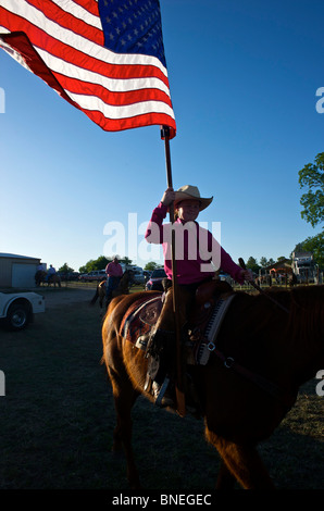 Cowgirl wehenden amerikanischen Fahne bei der Eröffnungsfeier des PRCA Rodeo Event in Texas, USA Stockfoto