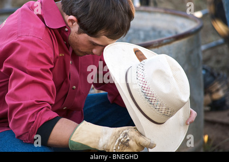 Cowboy sitzen halten Hut suchen enttäuscht nach Rodeo Veranstaltung an einer PRCA In Texas, USA Stockfoto