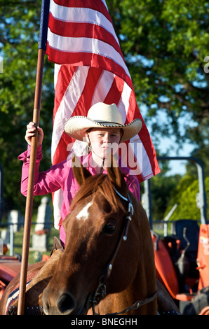 Cowgirl, die amerikanische Flagge winken PRCA Rodeo Event in Texas, USA Stockfoto