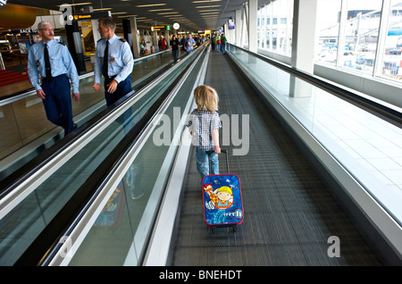 Drei Jahre alten Jungen auf seinem Weg zur Abflughalle am Flughafen Schiphol in den Niederlanden, Europa Stockfoto