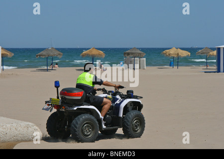 Lokale Polizisten patrouillieren auf einem Quad-Bike an den Stränden an der Küste von Valencia im Stadtteil Malvarrosa Stockfoto