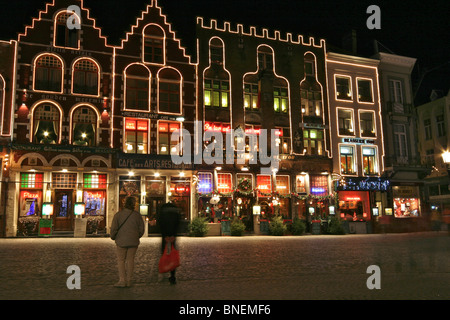 Gebäude bedeckt in Lichterketten an der Nordseite auf den gepflasterten Markt mit Weihnachtsschmuck und Shopper in Brügge Stockfoto