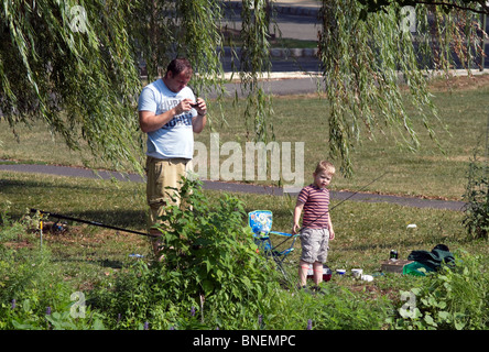 Vater und Sohn Angeln unter einen alten Weidenbaum. Stockfoto