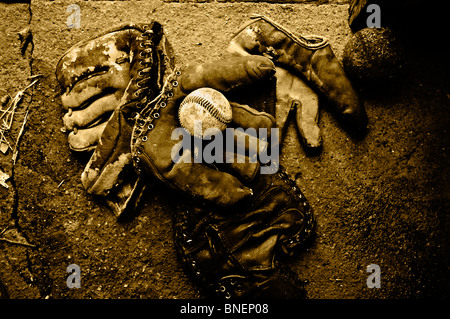 Verwittert, getragen von antiken 1950er Jahre Ära Baseball Handschuhe sammeln Staub in einem alten Bauernhaus auf der Mitte amerikanischen Prärien von Oklahoma Stockfoto