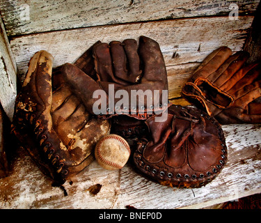 Verwittert, getragen von antiken 1950er Jahre Ära Baseball Handschuhe sammeln Staub in einem alten Bauernhaus auf der Mitte amerikanischen Prärien von Oklahoma Stockfoto