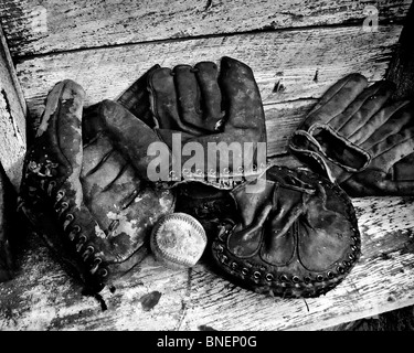 Verwittert, getragen von antiken 1950er Jahre Ära Baseball Handschuhe sammeln Staub in einem alten Bauernhaus auf der Mitte amerikanischen Prärien von Oklahoma Stockfoto