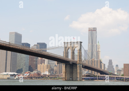 Brooklyn Bridge und dem East River mit Beekman Tower (von Frank Gehry entworfen) und das Woolworth Building im Hintergrund. Stockfoto