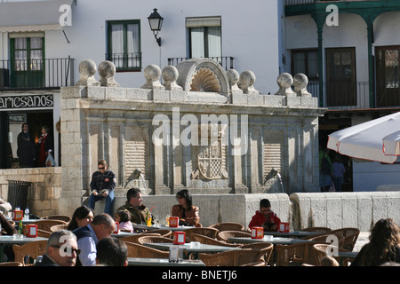 Stein Wasser-Funktion in der Plaza Mayor von Chinchón Menschen saßen am Café-Tisch mit Menschen auf der Suche auf Stockfoto