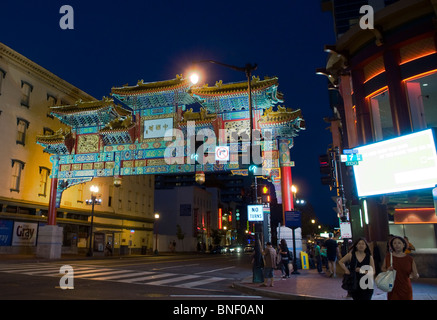 Zwei Damen über die Straße am Gallery in Washington DC mit dem Chinatown Torbogen im Hintergrund statt. Stockfoto