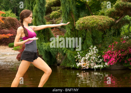 Schöne Brünette Frau in Yoga-pose Weiher im park Stockfoto