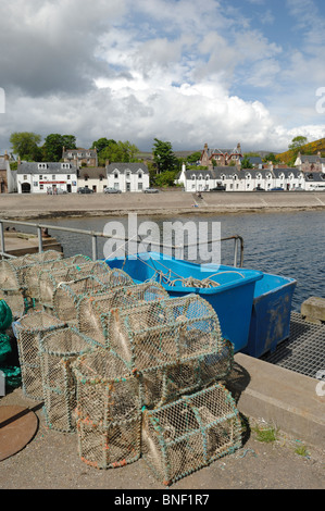 Hummer-Töpfe oder Gatter Dock seitlich am Ullapool in Ross und Cromarty Schottland mit den Dörfern Reihenhäuser hinter. Stockfoto