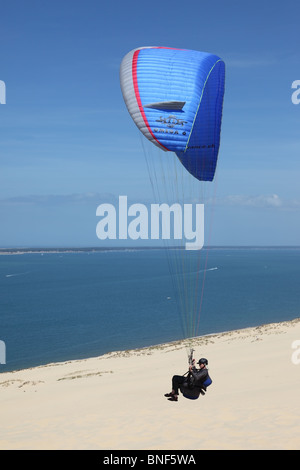 Gleitschirm fliegen über der Küste an den Dünen von Pyla in der Nähe von Arachon Frankreich Stockfoto