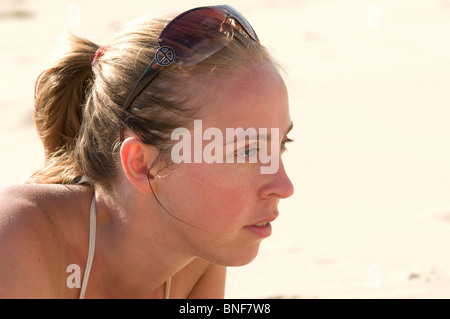 Profil einer Frau Sonnenbad mit Sonnenbrille auf dem Kopf Stockfoto