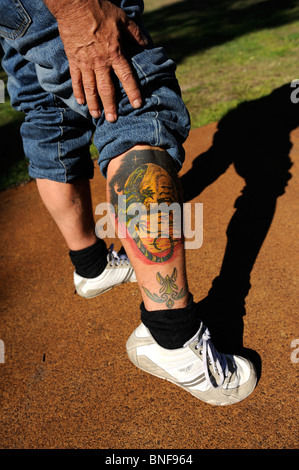 Tattoo mit Australian Aboriginal Flagge; Aborigines Tiermotive; und Portrait von Aborigines Mann. Perth, Western Australia, Australia Stockfoto