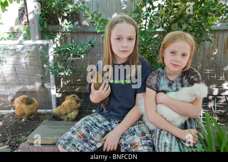 Kinder halten Hühner im Hühnerstall urbanen Hinterhof Stockfoto