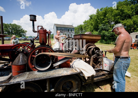 Männer einen Mais schälen Maschine bei einem antiken Gas und Dampf-Motor Show in Fort Hunter am Erie-Kanal in Betrieb. Stockfoto