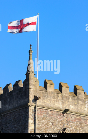 Englische Flagge von St. George von einem Kirchturm an einem sonnigen Tag fliegen Stockfoto