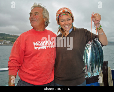 Eine Mädchen hält Makrele gefangen auf einem Angelausflug aus Lyme Regis, Dorset, England Stockfoto