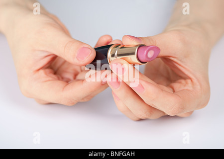 Roter Lippenstift in weiblichen Händen - Nahaufnahme Stockfoto