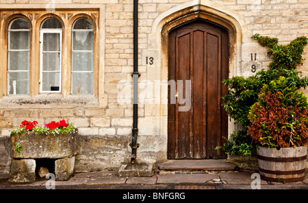 Alte hölzerne Eingangstür und zweibogigen Fenster der typischen alten Cotswold-Steinhaus in Wiltshire Dorf Sherston, England, Großbritannien Stockfoto