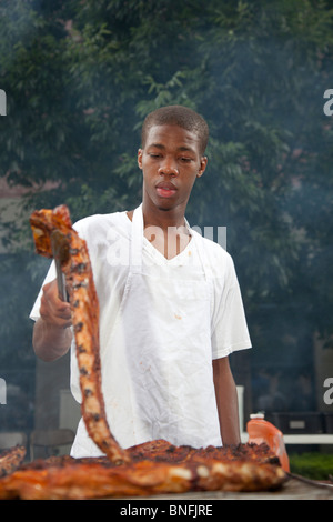 Detroit, Michigan - ein Restaurant-Mitarbeiter grillt Fleisch zum Verkauf bei einem Musikfestival. Stockfoto