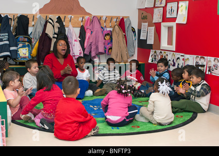 Kindergärtnerin singt mit ihren Schülern Stockfoto