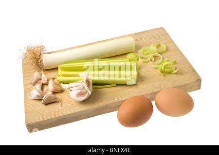 Gruppe von Eiern, Lauch und Knoblauch auf ein Schneidbrett aus Holz isoliert auf einem weißen Hintergrund. Stockfoto