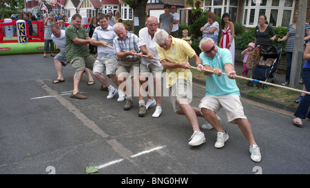 Eine Gruppe von Männern, die Teilnahme an einem Tauziehen-Wettbewerb bei einem Straßenfest bei einer "Big Lunch" Veranstaltung in North Cheam London Uk Stockfoto