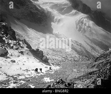 Porters kommen die letzten Hänge hinauf zum Pass im Lapsang-La mit Gletscher unterhalb der Kangchenjunga Region Osten Nepals Stockfoto