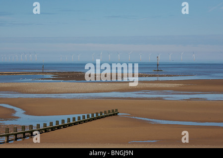 Ebbe in Rhyl; am Horizont Windkraftanlagen Rhyl Flats Bauernhof; eine hölzerne Buhne erstreckt sich über den Strand. Stockfoto