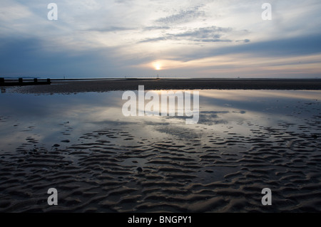 Abend-Himmel und Reflexionen bei Ebbe.  Am Horizont können die Turbinen des Windparks Rhyl Flats gesehen werden. Stockfoto