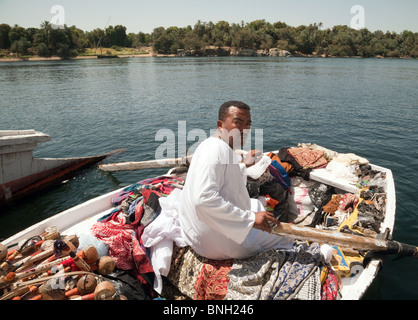 Ägypten Lebensstil; ein ägyptischer Markthändler mit seinen Waren in einem Ruderboot, das versucht, an Touristen zu verkaufen, der Nil in Assuan, Oberägypten Afrika Stockfoto