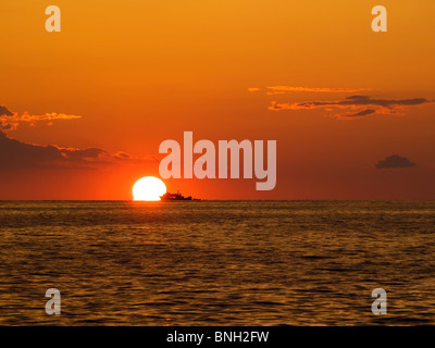 Schöner Sonnenuntergang mit einem Fischerboot am Horizont irgendwo entlang der adriatischen Küste. Stockfoto