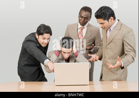 Vier Unternehmer auf der Suche schockiert vor einem laptop Stockfoto